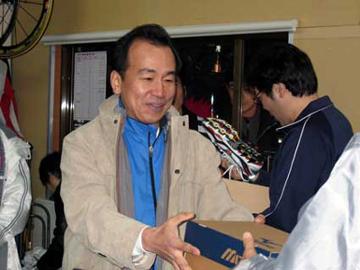 協賛のミズノのシューズを配る俵木さん。