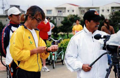 古代さんも宮古島ではトライアスロンシーン。監督顔負けの活躍ぶり(左)。右は宮古島テレビカメラマンの砂川さん